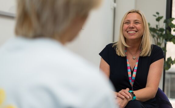 A member of staff smiling during a face-to-face appointment with a student